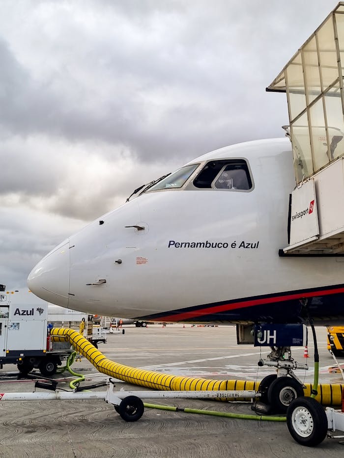 Commercial airplane at a terminal gate in Rio de Janeiro, ready for boarding. Cloudy skies.